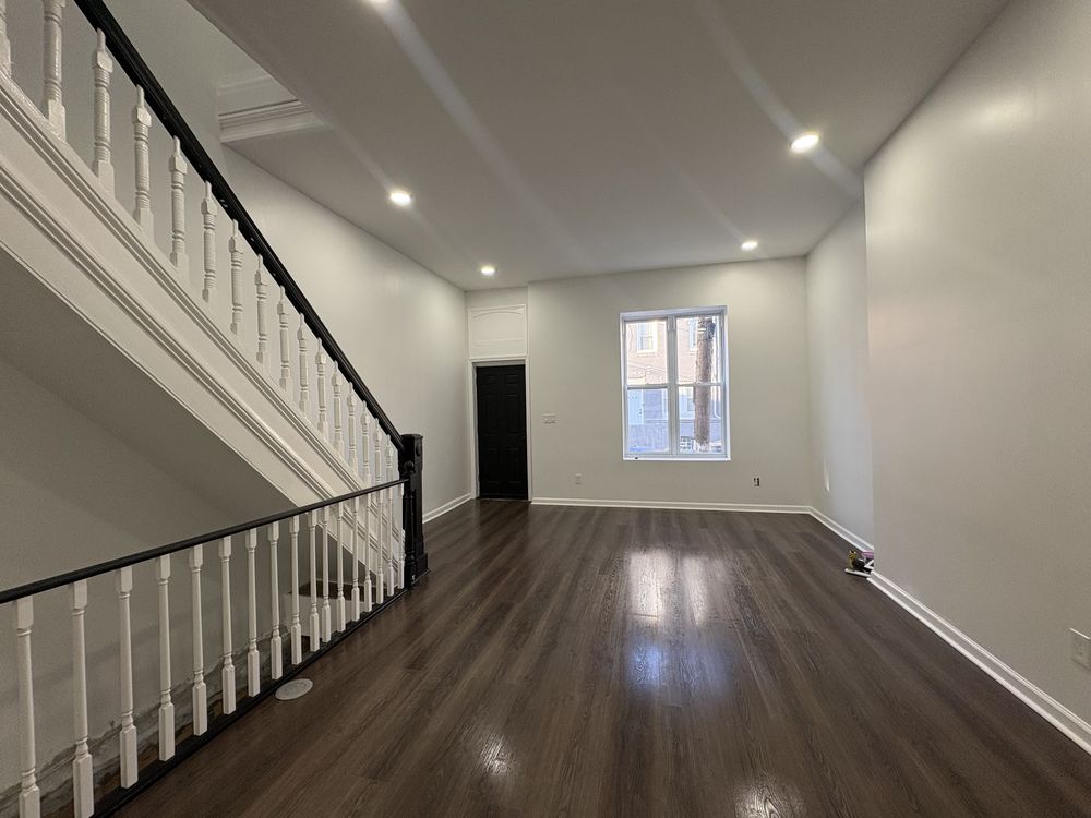 Finished living room with new floors and restored staircase